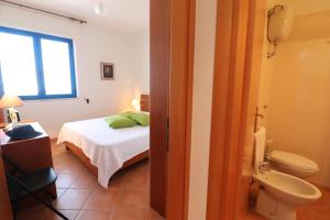 a bedroom with a bed and a bathroom with a toilet at Casa Rossana a Otranto in Otranto