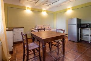 a kitchen and dining room with a table and a refrigerator at Rosaspina - Appartamento 3 in Capalbio
