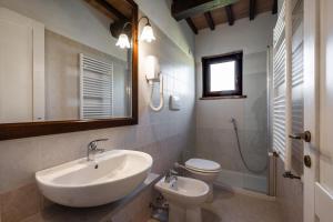 a bathroom with a sink and a toilet and a mirror at Rosaspina - Appartamento 3 in Capalbio +15 photos