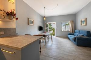 a kitchen and living room with a blue couch at Abaye 2 Pinot - Charm Adults Only in Soiano del Lago