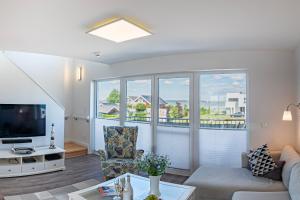 a living room with a couch and a tv at Fewo Ostseeflair by Seeblick Ferien in Kappeln