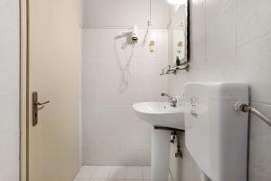 a white bathroom with a sink and a mirror at Dolphin Studio Sea View 10 in Keri