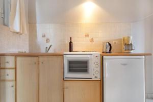 a kitchen with a white microwave and a refrigerator at Dolphin Studio Sea View 10 in Keri +12 photos