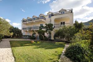 a large white building with a yard in front of it at Dolphin Studio Sea View 10 in Keri