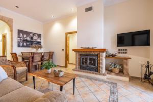 a living room with a fireplace and a table at Can León in Almodóvar del Río