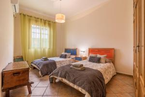 a bedroom with two beds and a window at Can León in Almodóvar del Río