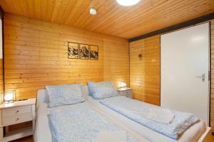 a bedroom with two beds and wooden walls at Ferienhaus 10 Rechbergblick in Bernau im Schwarzwald