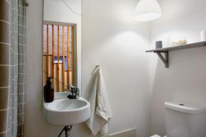 a white bathroom with a sink and a toilet at Calheta Beach House T2 in Calheta +23 photos