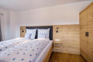 a bedroom with a large bed with a wooden headboard at Ferienwohnung Rosa in Gilching