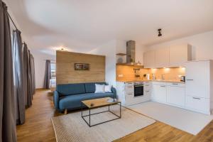 a living room with a blue couch and a kitchen at Ferienwohnung Rosa in Gilching