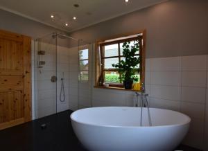 a large white tub in a bathroom with a window at Haus Mövenort in Lütow +13 photos