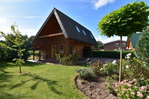 a home with a gambrel roof and a garden at Haus Mövenort in Lütow