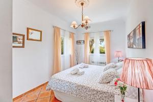 a white bedroom with a bed and a lamp at Dosmadres7 in Llucmajor
