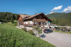 a house on a hill with a car parked in front at Nigglhof Apartment Maria in Redagno