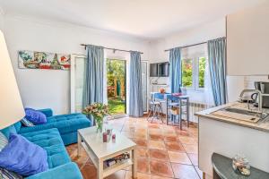 a living room with a blue couch and a kitchen at Dosmadres7 in Llucmajor