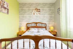 a bedroom with a wooden bed with two night stands at Jolie maison mitoyenne in Concarneau