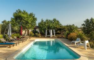 a pool with chaise lounge chairs and a playground at La Petite Maison De Noémie in Gras