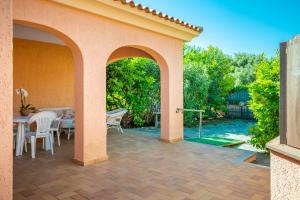 a patio with a table and chairs and a pool at Villetta Bifamiliare 2 in San Teodoro