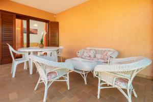 a patio with wicker chairs and a table and a table and chairs at Villetta Bifamiliare 2 in San Teodoro