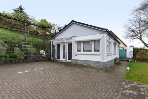 a small white house with a brick driveway at Ferienhaus Günther in Werder