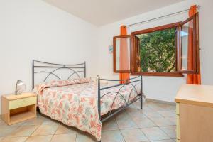 a bedroom with a bed and a window at Villetta Bifamiliare 2 in San Teodoro +17 photos