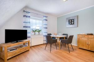 a living room with a tv and a table with chairs at Ferienwohnung Langenhorst in Raesfeld