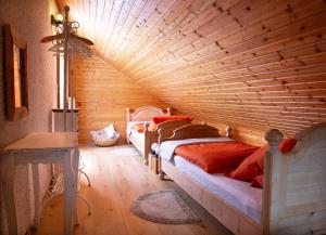 two beds in a room with a wooden ceiling at Die Bartlmühle in Windorf