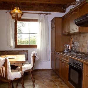 a kitchen with a wooden table and a dining room at Die Bartlmühle in Windorf