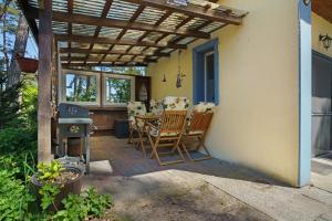 a patio with a table and chairs under a pergola at Bungalow Karsten in Kamminke