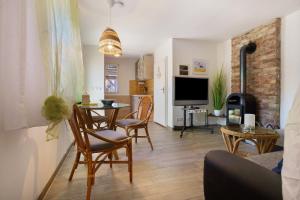 a living room with a table and chairs and a television at Bungalow Karsten in Kamminke