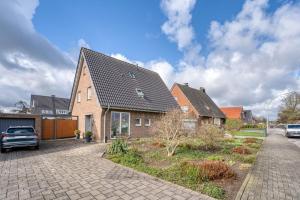 a brick house with a car parked in the driveway at Ferienwohnung Langenhorst in Raesfeld