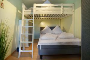a bedroom with a bunk bed with a ladder at Bungalow Karsten in Kamminke
