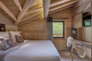 a bedroom with a bed in a wooden room at Chalet des joux in La Clusaz