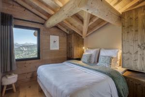 a bedroom with a large bed in a wooden room at Chalet des joux in La Clusaz