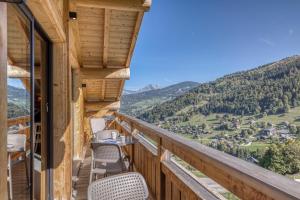 a balcony with chairs and a view of the mountains at Chalet des joux in La Clusaz