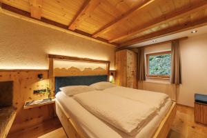 a bedroom with a large bed in a room at Mühlanderhof Apt Piz Lad in Resia