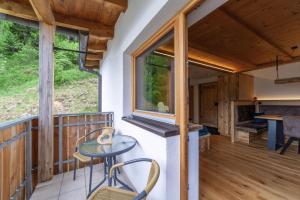 a room with a table and chairs on a balcony at Mühlanderhof Apt Piz Lad in Resia