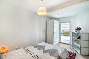 a white bedroom with a bed and a window at Vogtshaus in Gernsbach