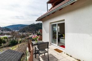 a balcony of a house with a table and a window at Vogtshaus in Gernsbach
