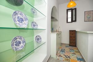 a glass shelf with blue and white plates on it at Apartamento Geranio in Vejer de la Frontera +17 photos