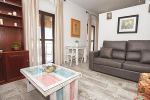 a living room with a couch and a table at Apartamento Geranio in Vejer de la Frontera