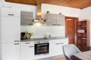 a white kitchen with a sink and a stove at Flying Hirsch in Stall