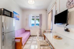 a living room with a purple couch and a refrigerator at Elia Perigiali Lefkada in Nydri