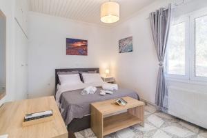 a bedroom with a bed and a table and a window at Elia Perigiali Lefkada in Nydri