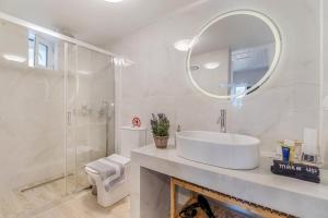a white bathroom with a sink and a mirror at Elia Perigiali Lefkada in Nydri +15 photos