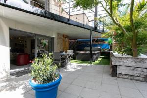 a patio with potted plants in front of a building at Gîte Les Galets Blancs in Trébeurden