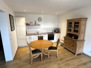 a kitchen with a wooden table and chairs in a kitchen at Hofberg Villa - Appartment in Landshut