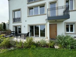 a house with a balcony and a table in the yard at Hofberg Villa - Appartment in Landshut