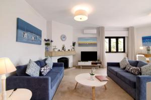 a living room with two blue couches and a fireplace at Casa Harlequin in Vale do Lobo