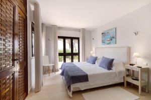 a bedroom with a bed with blue pillows at Casa Harlequin in Vale do Lobo